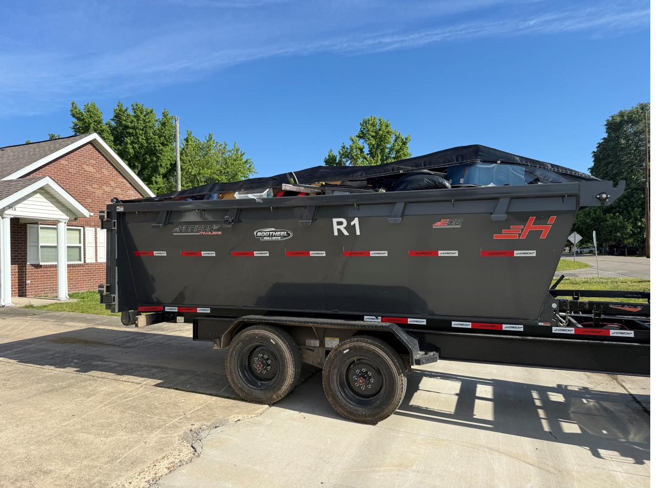 Loaded roll-off container on a trailer at a job site in Dexter, Missouri